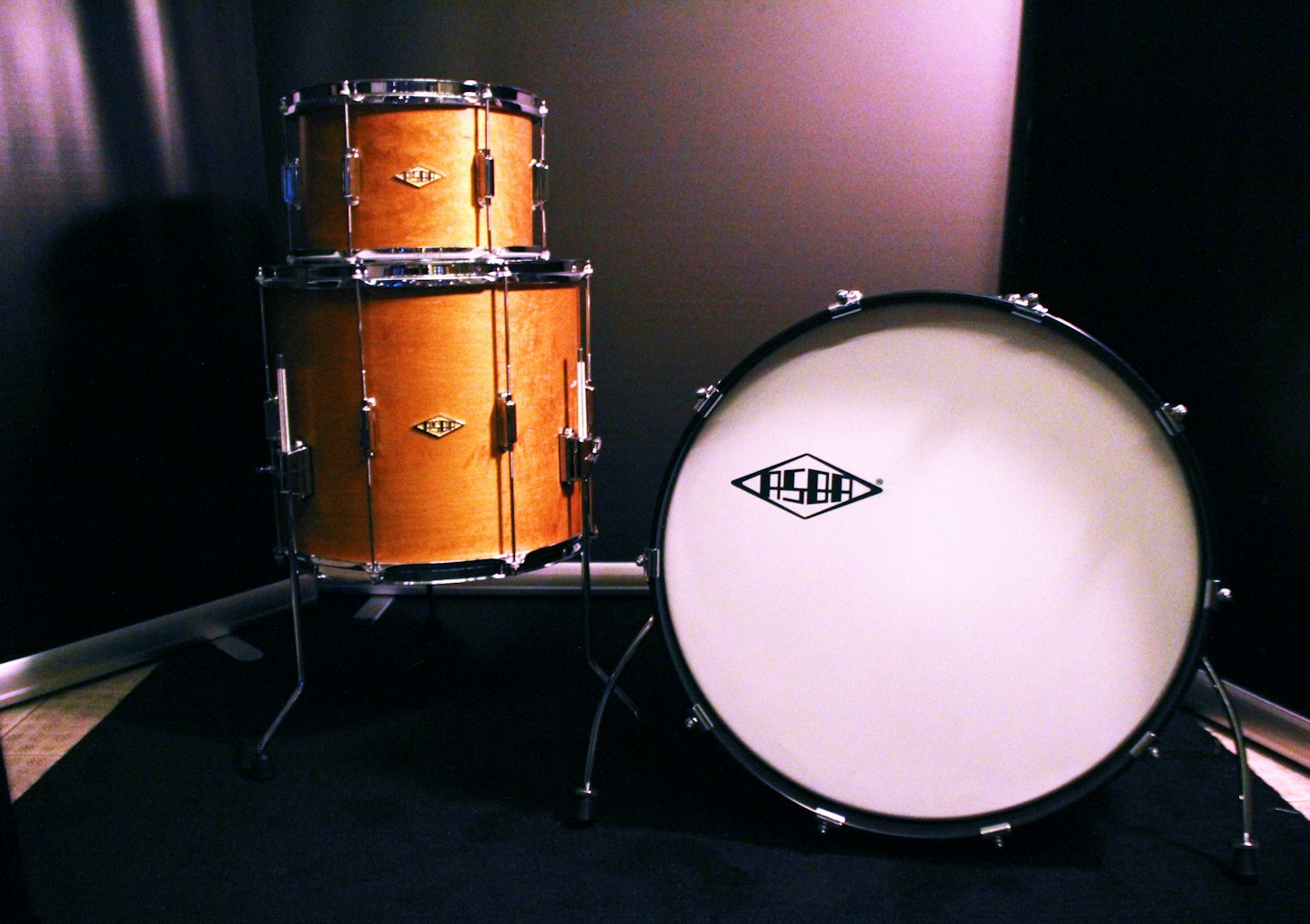 Wooden drums with chrome hardware arranged on the floor.